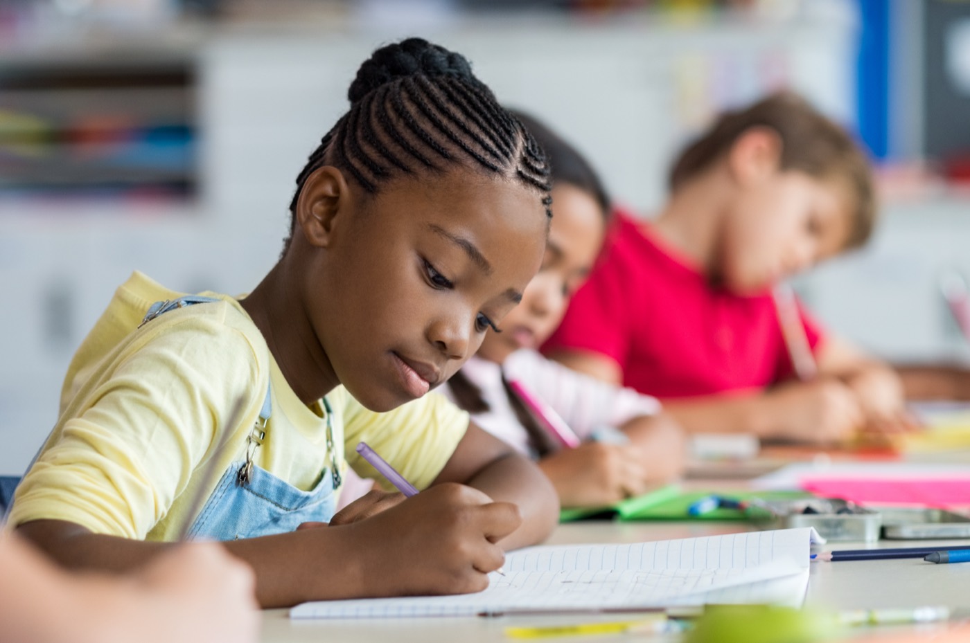 A young student concentrating on her written work in class